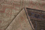 Distressed Oushak pile in beige, dusty pink, showing fringed edge and woven foundation.