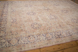 Distressed vintage Sivas rug detail with arabesque border and floral field in dusty rose and mauve.