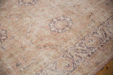 Distressed Sivas rug pile, showing faded dusty rose, pale gold, and aubergine floral motifs.