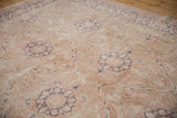 Distressed Sivas rug with worn dusty rose pile and dark aubergine floral medallion.