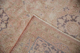 Worn dusty rose pile and floral border detail of the hand-knotted Sivas rug.