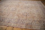Distressed vintage Sivas carpet detail: dusty rose floral medallions and arabesque border with wear.