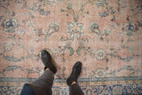 Distressed vintage Sparta carpet with dusty rose field, floral vinery, and abrashed texture.