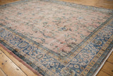 Distressed Sparta carpet detail: faded dusty rose field with vinery and sky blue border.