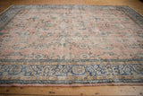 Distressed dusty rose field with scrolling floral palmettes and blue-gold border.