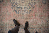 Faded blush and navy floral patterns on a distressed vintage Sparta carpet.