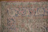 Low pile, distressed Sparta carpet border, showing faded blush, navy, ivory floral motifs.