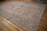 Distressed floral tendril border with visible wear in blush and navy blue.