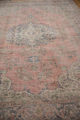 Distressed vintage Sparta carpet showing wear to foundation, blush and navy floral patterns.