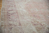 Worn texture of a vintage Sparta carpet, highlighting faded rose and aubergine palmettes.