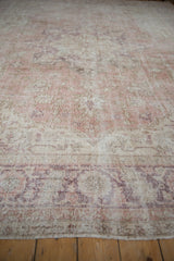 Distressed texture of the vintage Turkish Sparta rug, showing time-softened rose, ivory, and aubergine floral motifs.