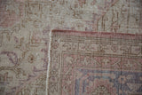 Distressed dusty rose and ivory pile of the vintage Sparta rug with its hand-knotted foundation.