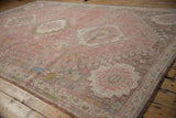 Distressed vintage Abadeh carpet, showing worn pink and sand field with stepped medallion.