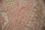 Distressed vintage Abadeh carpet pile showcasing stepped patterns and playful pink, brown, blue motifs.