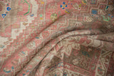 Playful pink, beige, and blue geometric patterns on a folded vintage distressed Abadeh carpet.
