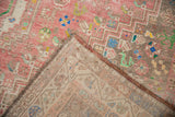Distressed pink Abadeh rug corner detail, revealing worn pile and woven foundation.