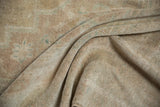 Distressed vintage Oushak rug pile with soft sand, beige, and faded mint green hues.