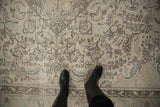Vintage distressed Tabriz carpet with faded curvilinear floral motifs in muted tones.