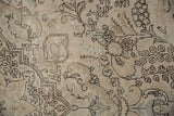 Distressed vintage Tabriz carpet showing subtle floral vinery in faded ivory, charcoal, and seafoam green.