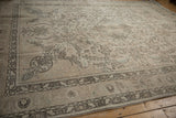 Distressed vintage Tabriz carpet corner with pale charcoal floral vinery and intricate border.