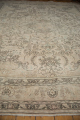 Faded floral vinery and geometric border detail on this distressed vintage Tabriz carpet.
