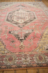 Vintage Oushak rug detail: dusty pink field with geometric vinery and serpent border.