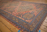 Vintage Caucasian Soumac rug field with madder red, starburst florals, and geometric chevron borders.
