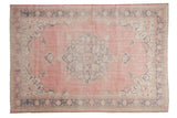 Distressed Turkish Sparta carpet with roundel medallion, abrashed pale red and mauve tones.
