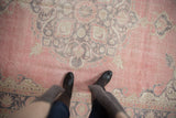 Distressed vintage Turkish Sparta carpet, soft cochineal red field, faded grey medallion, even wear.