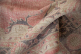 Textural detail of a folded vintage distressed Sparta rug, highlighting soft pink and faded mauve tones.