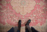 Distressed raspberry pink Sparta rug with ivory floral patterns and worn texture.