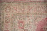 Distressed vintage Sparta carpet with raspberry pink floral arabesques and worn ivory pile.