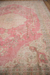 Distressed raspberry pink, ivory, and grey floral motifs on a vintage Sparta carpet.