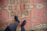 Distressed Turkish Sparta carpet detail with faded raspberry field, blue floral motifs, visible foundation wear.
