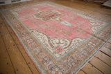 Distressed vintage Sparta rug with faded raspberry field, vine floral motif, and visible even wear.