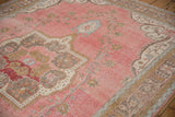 Distressed vintage Sparta carpet's faded raspberry field, gold, and dusty blue border patterns.