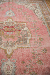 Distressed Sparta carpet with abrashed raspberry pink field and muted gold vine motif.