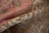 Worn pile texture of the distressed Sparta carpet's faded raspberry field and neutral patterns.