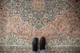 Distressed vintage Sparta carpet, faded blue and peach floral patterns, showing wear.