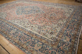 Distressed vintage Sparta carpet with cantaloupe field, denim blue borders, floral vinery.