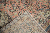 Folded corner of vintage Sparta rug showing distressed peach pile with pale blue florals and hand-knotted reverse.