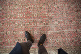 Distressed vintage Sparta carpet with faded dusty rose field, ivory vinery, worn texture.
