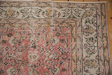 Distressed corner of Sparta rug, with dusty rose, ivory, and moss green vinery.