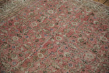 Distressed dusty red rose Sparta carpet pile showing worn scrolling vinery and blue blooms.