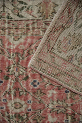Distressed vintage Sparta carpet: faded dusty rose scrolling vinery pile and hand-knotted reverse.