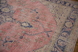 Textured dusty pink field of a distressed vintage Sparta rug with cobalt floral details.