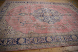 Distressed dusty pink field with scalloped contour and cobalt blue border pattern.