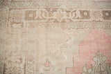 Evenly worn pile showing the Samovar border detail of a distressed Turkish Oushak carpet.