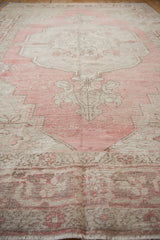 A low perspective highlights the even wear and texture on this distressed dusty blush Oushak carpet.