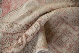 Softly folded vintage Oushak rug displaying its low pile and even, time-softened texture.